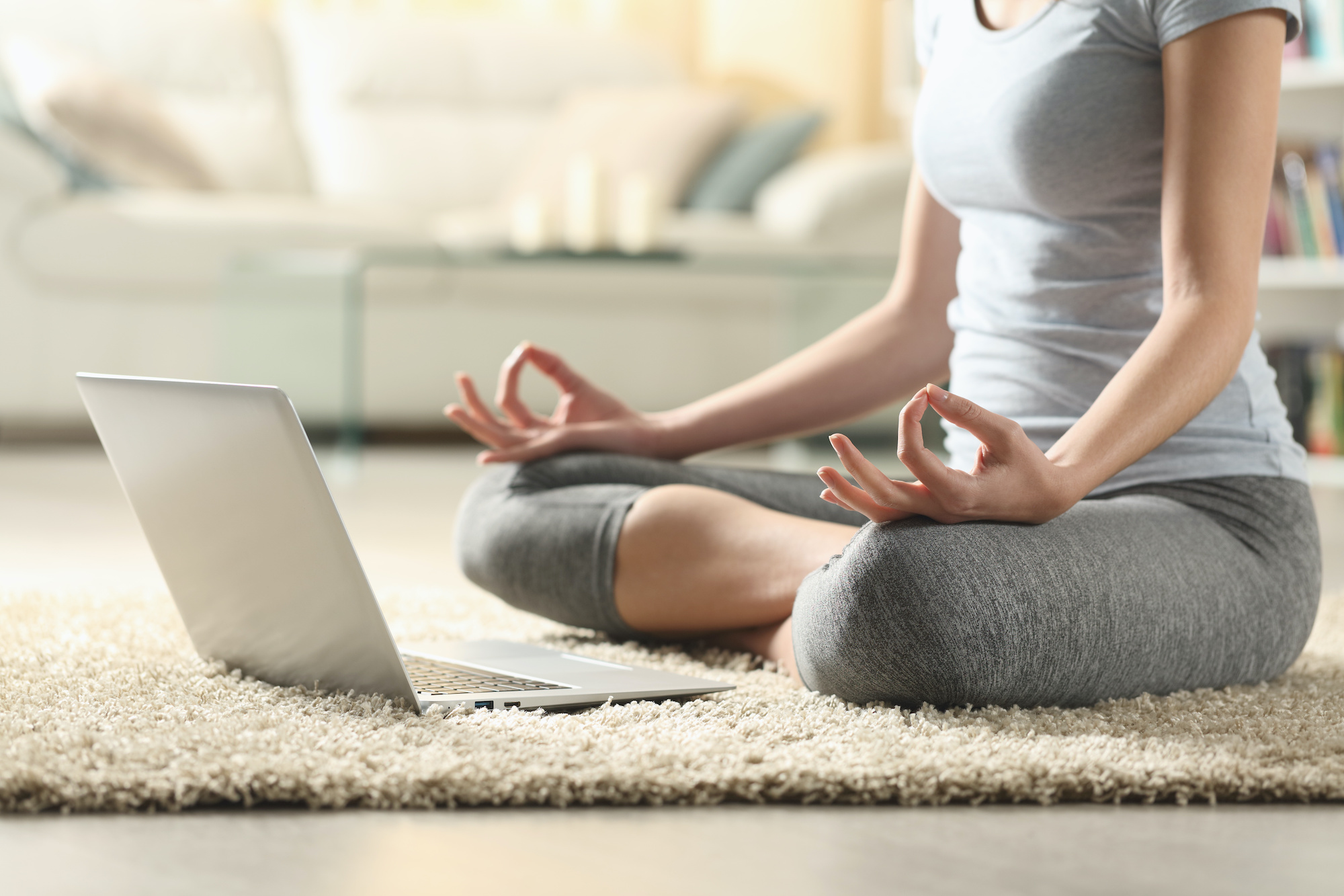 Yoga von zu Hause aus. Eine Frau meditiert beim Onlineyoga.